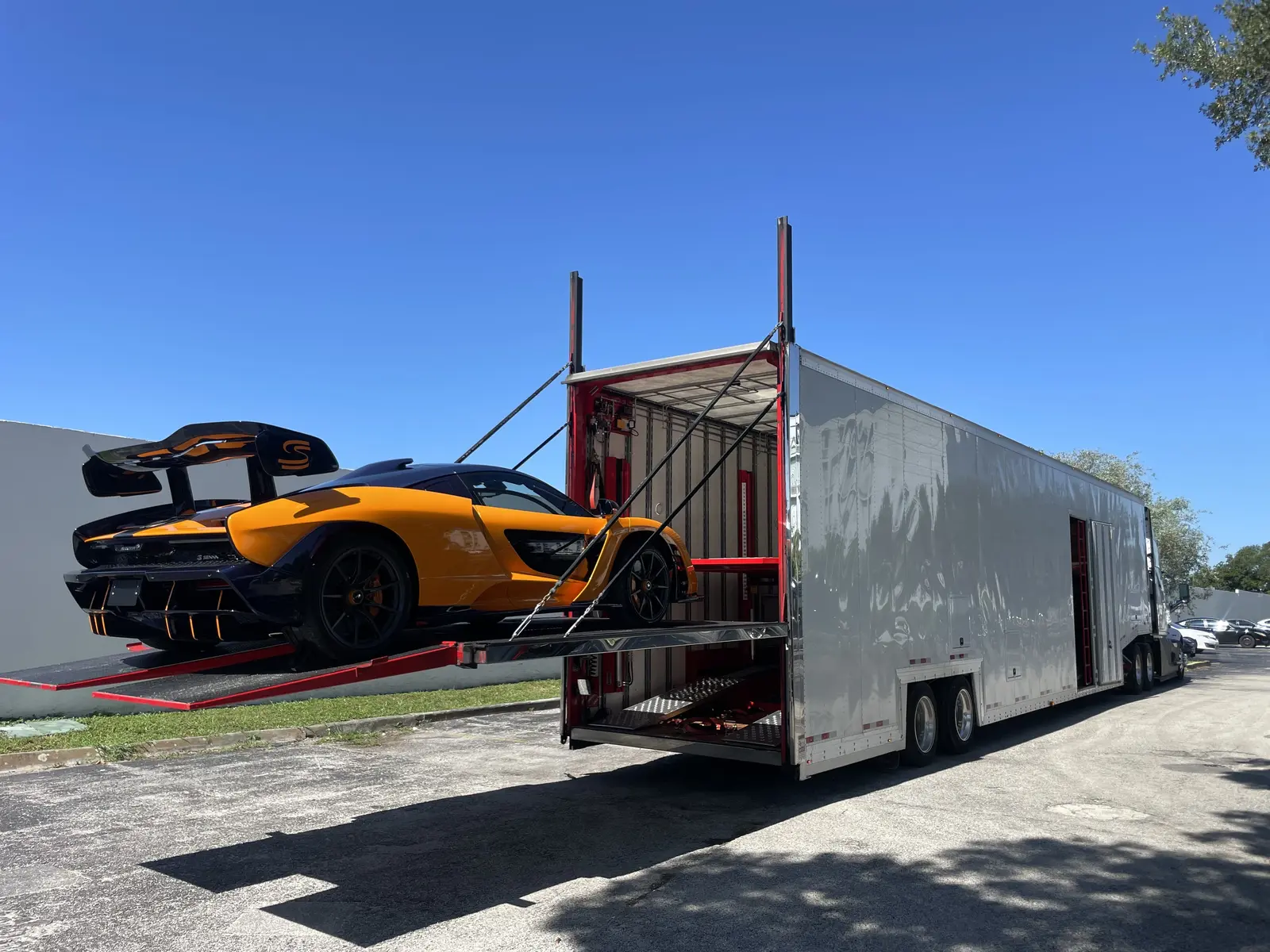 Sports car being loaded into a covered enclosed car trailer